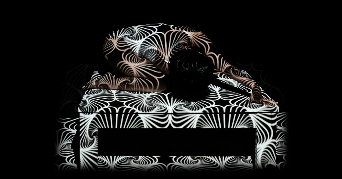 幾何学模様のプロジェクションが投影された人物アート